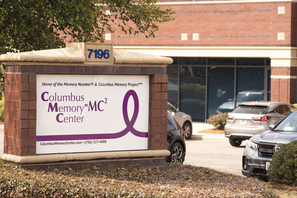 columbus-memory-center-georgia Exterior view of the Wellington Alzheimer's Research & Treatment Center building, showcasing a well-maintained facility with palm trees and a clear, inviting entrance. The image represents a dedicated center for Alzheimer's disease research, treatment, and patient care