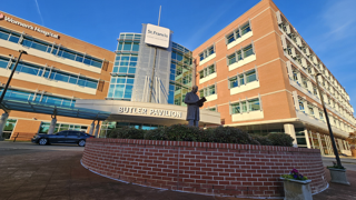 Exterior view of the Wellington Alzheimer's Research & Treatment Center building, showcasing a well-maintained facility with palm trees and a clear, inviting entrance. The image represents a dedicated center for Alzheimer's disease research, treatment, and patient care